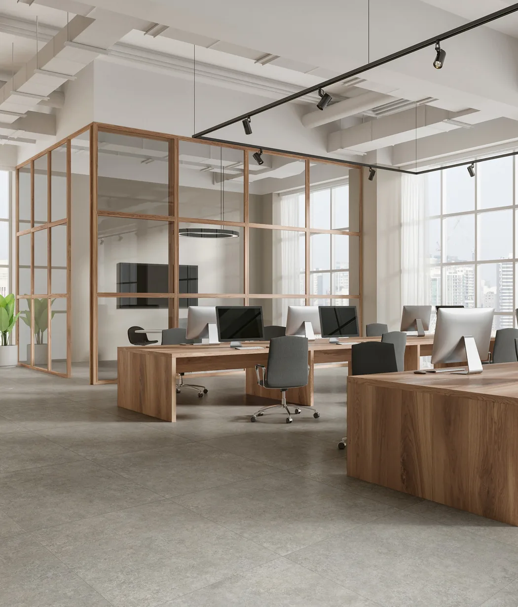 A bright open-plan floor: timber desks and a timber-framed glass room, daylight through tall curtained windows.