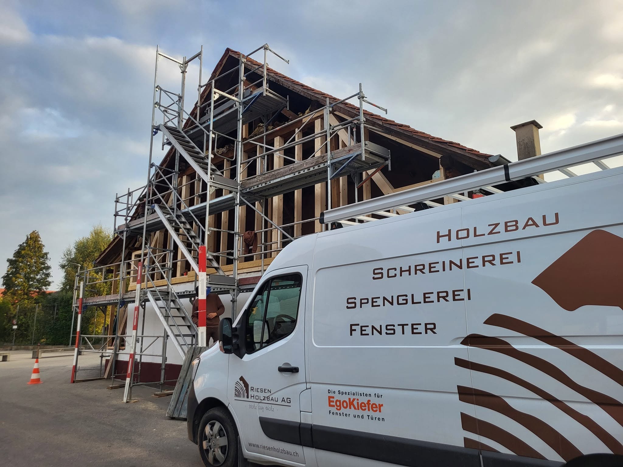 Riesen Holzbau AG van at a building site under scaffolding, lettered Holzbau, Schreinerei, Spenglerei, Fenster